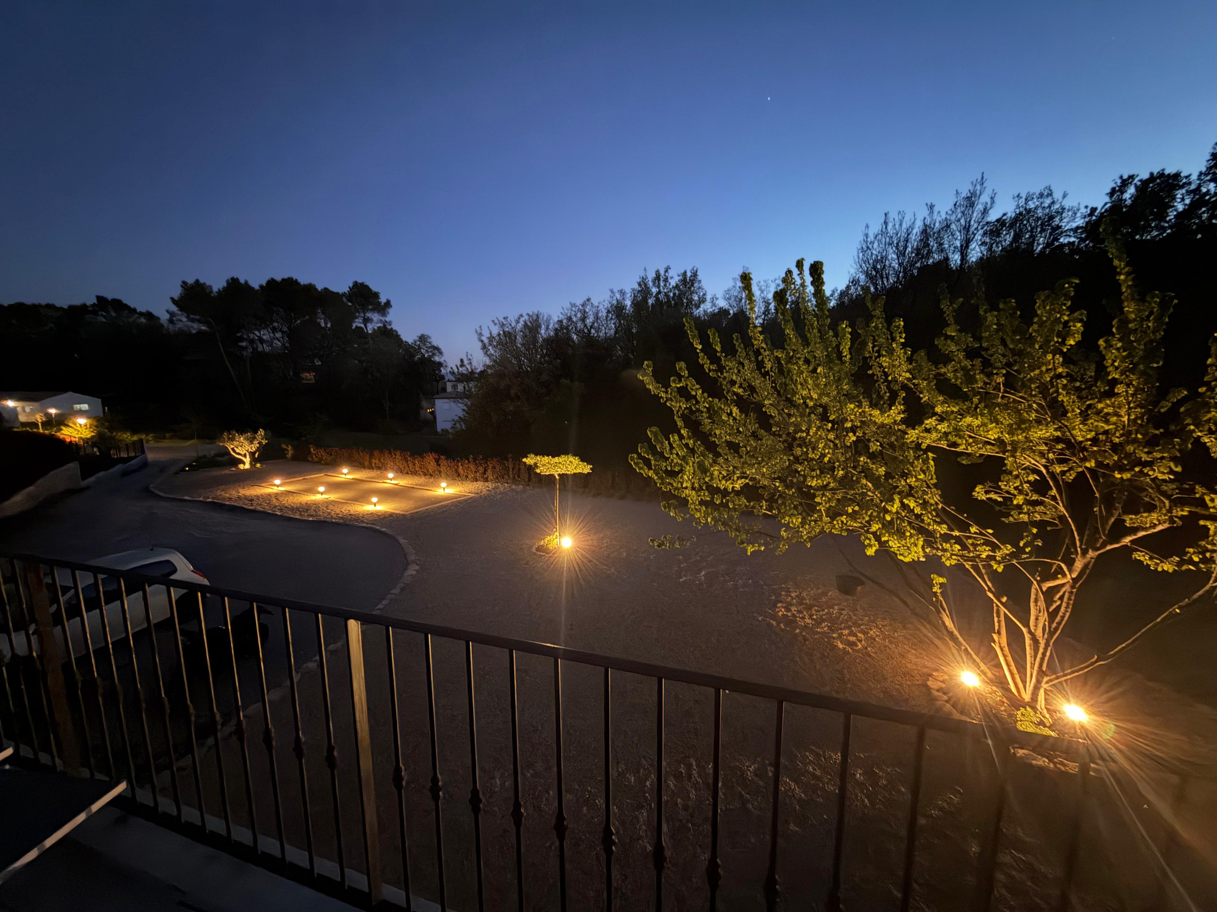 Allée d'entrée éclairée à la tombée de la nuit, aménagement paysager d'une villa en Provence